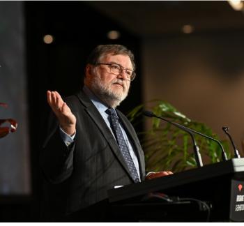 Prof Haymet speaking at a podium at the International Data Week Conference