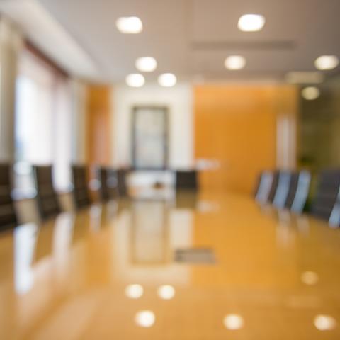 Blurred image of board room table and chairs 