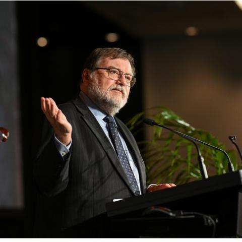 Prof Haymet speaking at a podium at the International Data Week Conference