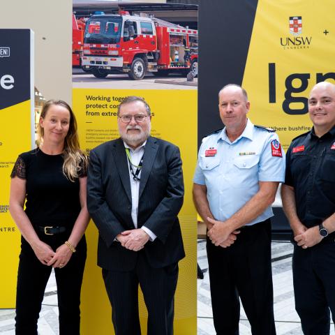 Four people stand in front of the UNSW Ignite banner 