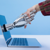 Human hand shaking a robot hand that is emerging from a laptop screen