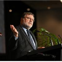 Prof Haymet speaking at a podium at the International Data Week Conference