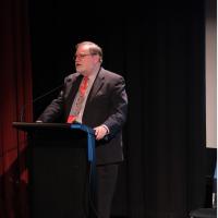 Prof Tony Haymet speaking into a microphone in front of a lectern.