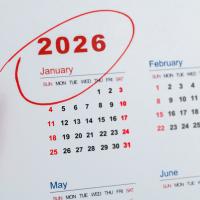 A photo of a calendar. The year 2026 is circled in red ink and the red marker pen sits beside the calendar. 